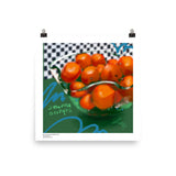 Satsuma oranges in a fluted glass bowl on a green table against a checkered background. By Laura Hunt